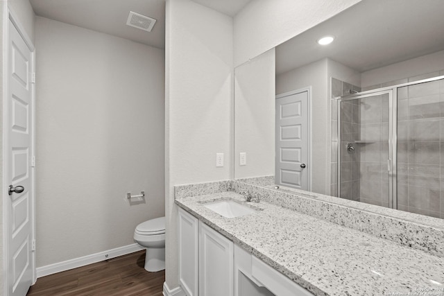 bathroom with toilet, an enclosed shower, vanity, and hardwood / wood-style flooring