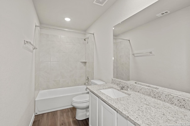 full bathroom with toilet, vanity, tiled shower / bath combo, and hardwood / wood-style flooring