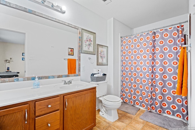 bathroom featuring toilet, vanity, and tile patterned flooring