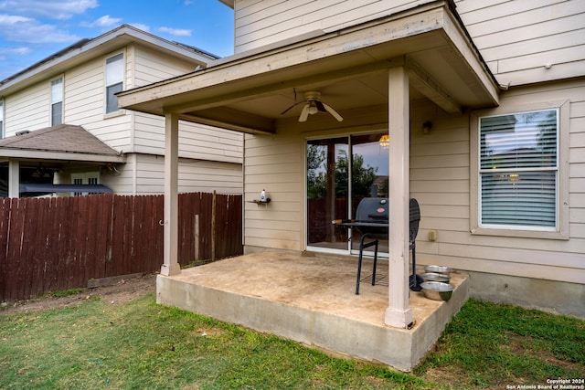 property entrance featuring ceiling fan, a lawn, and a patio