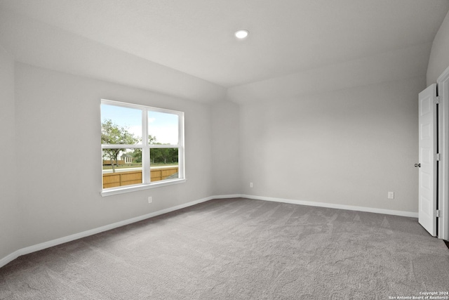 unfurnished room featuring carpet and lofted ceiling