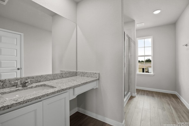 bathroom featuring a shower with door, vanity, and wood-type flooring