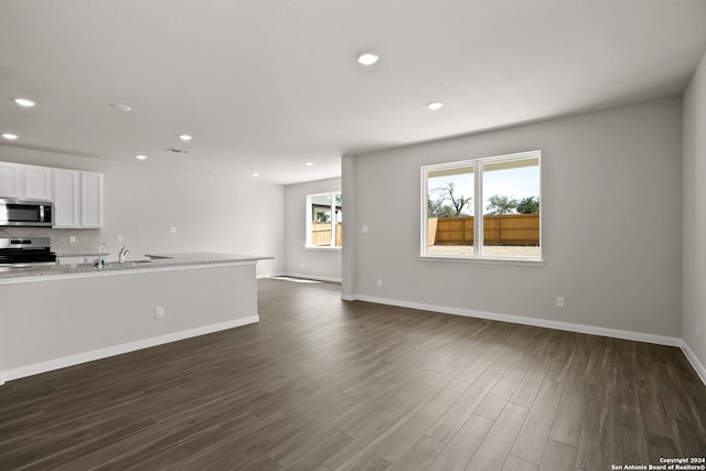 unfurnished living room with dark hardwood / wood-style floors and sink