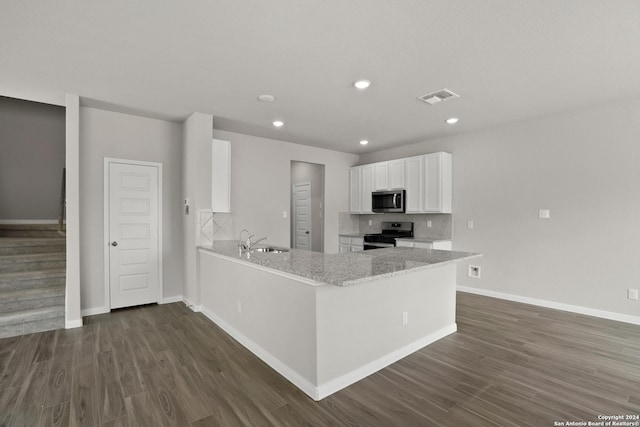 kitchen with kitchen peninsula, light stone countertops, stainless steel appliances, sink, and white cabinetry