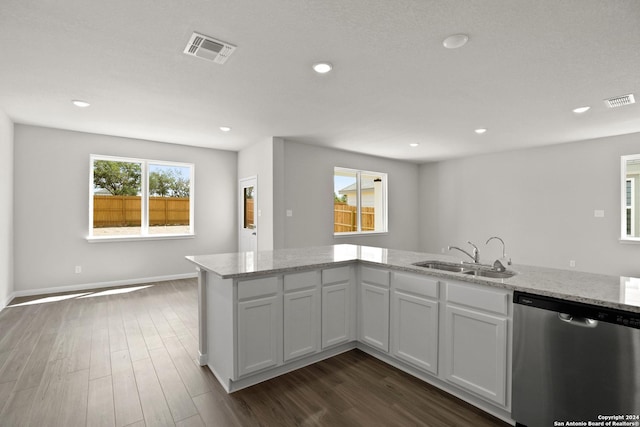 kitchen with light stone countertops, white cabinetry, sink, and stainless steel dishwasher