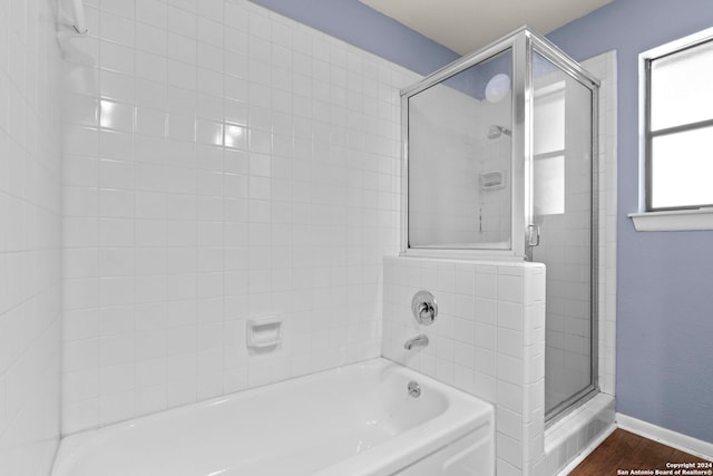 bathroom with wood-type flooring and shower with separate bathtub