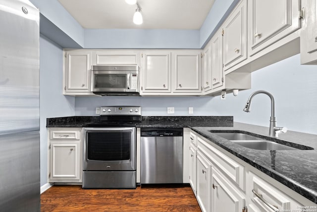 kitchen with dark hardwood / wood-style flooring, white cabinetry, sink, and appliances with stainless steel finishes