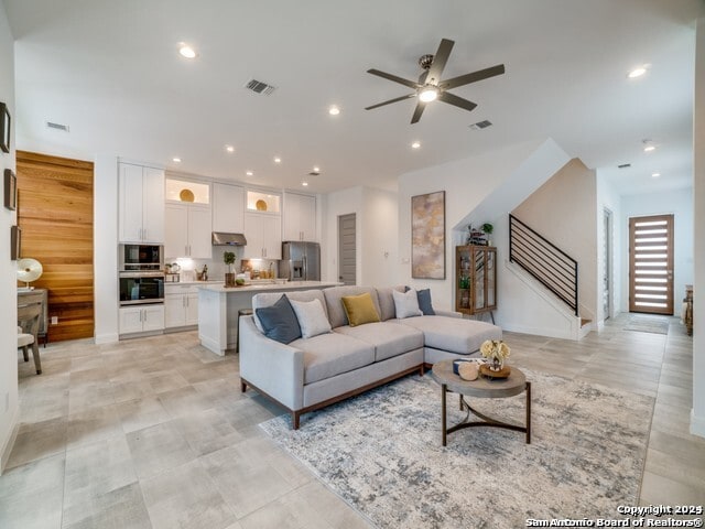 living room with light tile patterned floors and ceiling fan