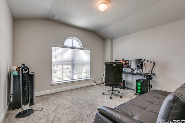 carpeted office featuring lofted ceiling and a healthy amount of sunlight