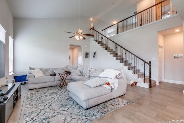 living room featuring ceiling fan, light hardwood / wood-style flooring, and high vaulted ceiling