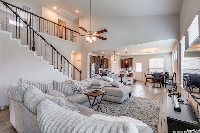 living room with high vaulted ceiling, ceiling fan, and hardwood / wood-style floors