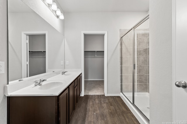 bathroom featuring wood-type flooring, vanity, and a shower with shower door