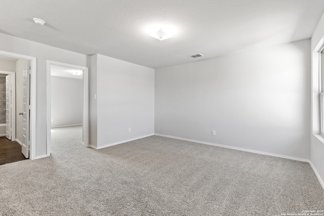 spare room featuring carpet floors and a textured ceiling