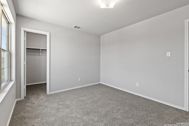 unfurnished bedroom featuring carpet floors, a closet, and a walk in closet