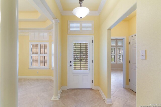 tiled entrance foyer featuring ornamental molding and ornate columns