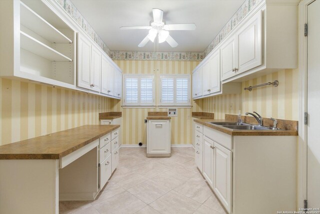 kitchen with white cabinetry, sink, and light tile patterned floors