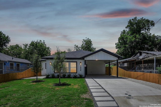 view of front of house featuring a carport and a yard