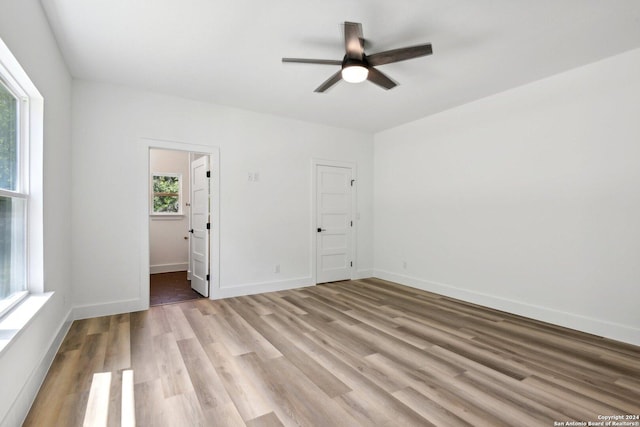 unfurnished bedroom featuring ensuite bathroom, light hardwood / wood-style flooring, and ceiling fan