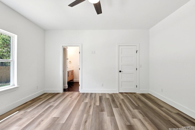 unfurnished bedroom featuring ensuite bathroom, ceiling fan, light hardwood / wood-style floors, and a closet