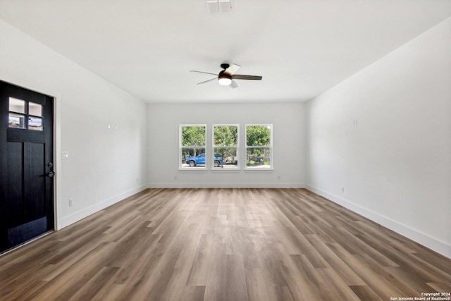 unfurnished living room featuring hardwood / wood-style flooring and ceiling fan