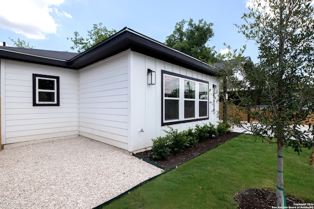 view of side of property with a yard and a patio