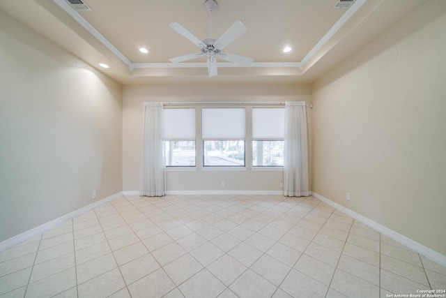 tiled spare room featuring a tray ceiling, ceiling fan, and crown molding