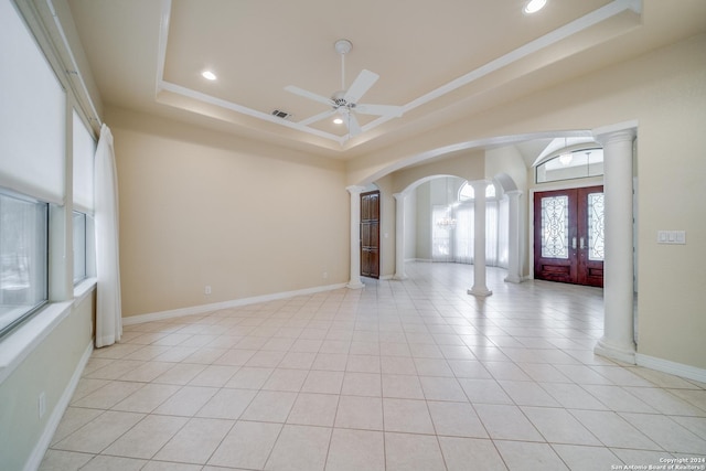 entrance foyer featuring french doors, decorative columns, a raised ceiling, ceiling fan, and light tile patterned floors