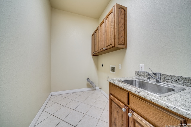 clothes washing area featuring sink, cabinets, washer hookup, electric dryer hookup, and light tile patterned floors