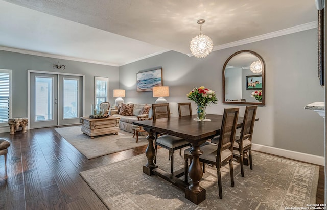 dining space featuring crown molding, dark wood-type flooring, a chandelier, and french doors