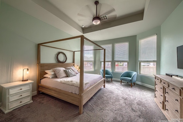 carpeted bedroom featuring ceiling fan and a tray ceiling