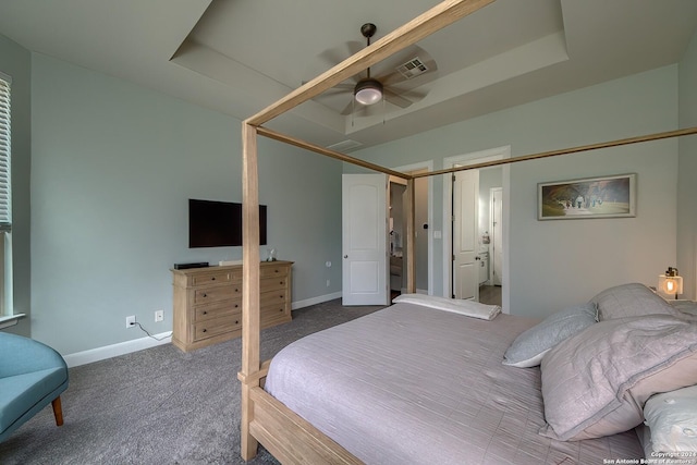 carpeted bedroom featuring ceiling fan and a raised ceiling