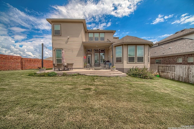 rear view of property featuring a patio area and a lawn