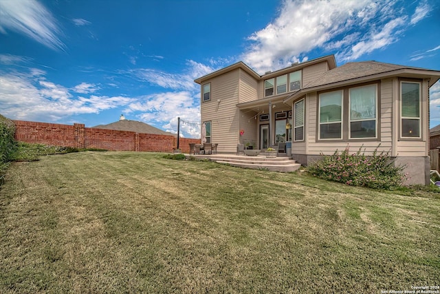 back of house with a patio area and a lawn