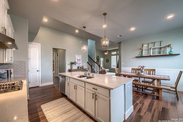 kitchen featuring sink, white cabinetry, a kitchen island with sink, appliances with stainless steel finishes, and light stone counters