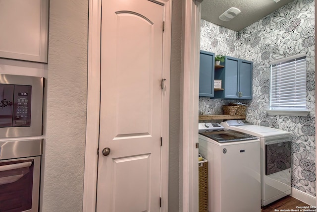 laundry room featuring cabinets, dark hardwood / wood-style flooring, and washer and clothes dryer