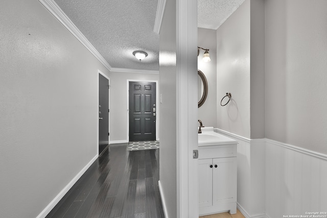 hall featuring ornamental molding, sink, a textured ceiling, and dark hardwood / wood-style floors