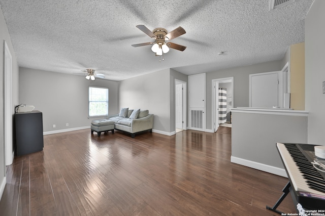 living area featuring dark hardwood / wood-style floors, ceiling fan, and a textured ceiling