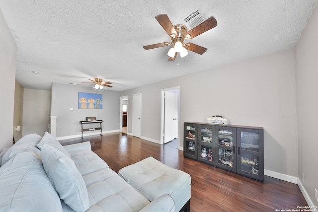 living room featuring dark wood-type flooring, a textured ceiling, and ceiling fan