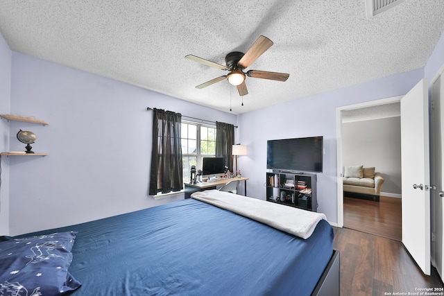 bedroom with a textured ceiling, ceiling fan, and dark hardwood / wood-style floors