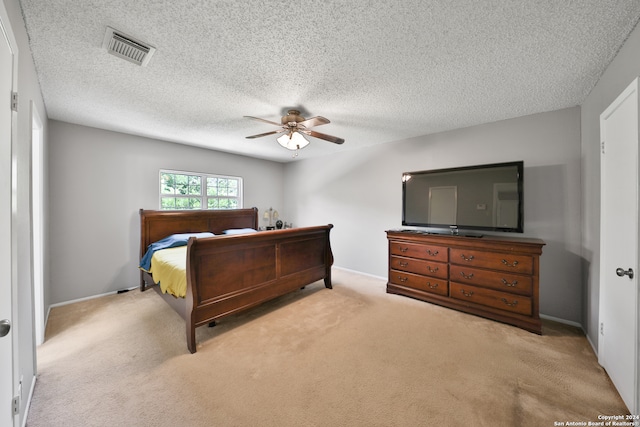 carpeted bedroom featuring a textured ceiling and ceiling fan