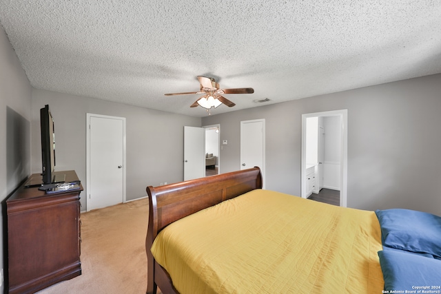 bedroom featuring a textured ceiling, carpet flooring, connected bathroom, and ceiling fan