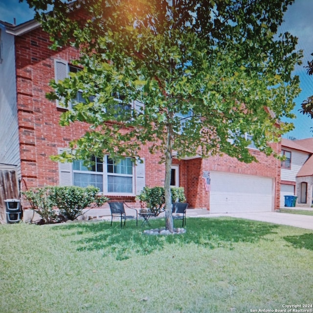 view of front of house featuring cooling unit, a garage, and a front lawn