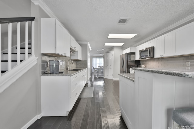 kitchen featuring appliances with stainless steel finishes, backsplash, light stone counters, and sink