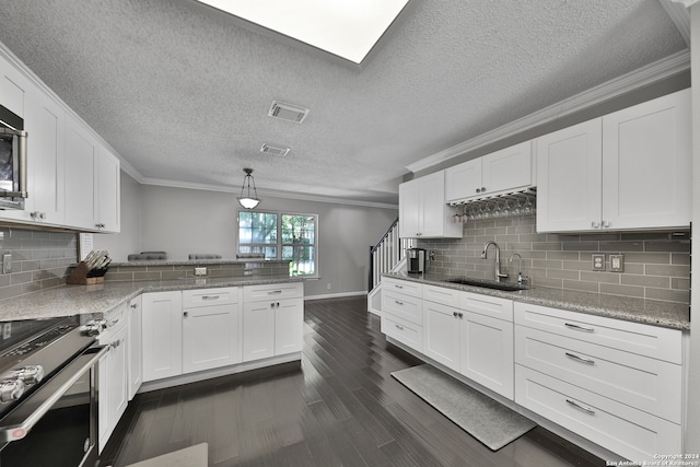 kitchen featuring sink, kitchen peninsula, crown molding, and backsplash