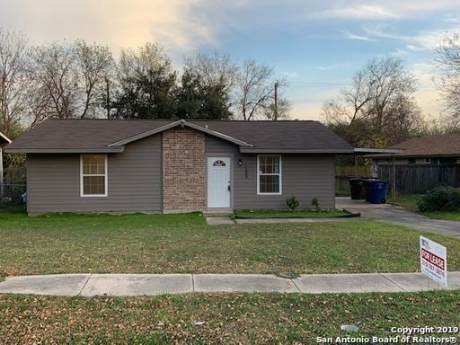 single story home featuring a lawn