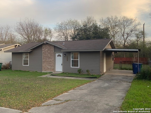 ranch-style home with a yard and a carport