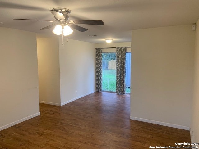 empty room with ceiling fan and dark hardwood / wood-style flooring