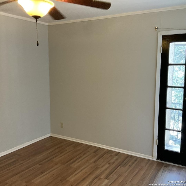 spare room with crown molding and dark wood-type flooring