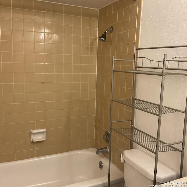 bathroom featuring tiled shower / bath combo and toilet