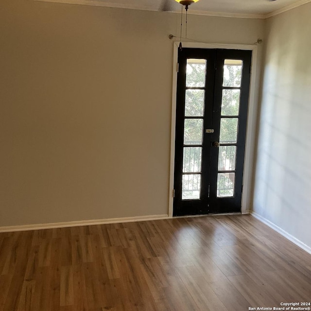 interior space with french doors, ornamental molding, and hardwood / wood-style floors